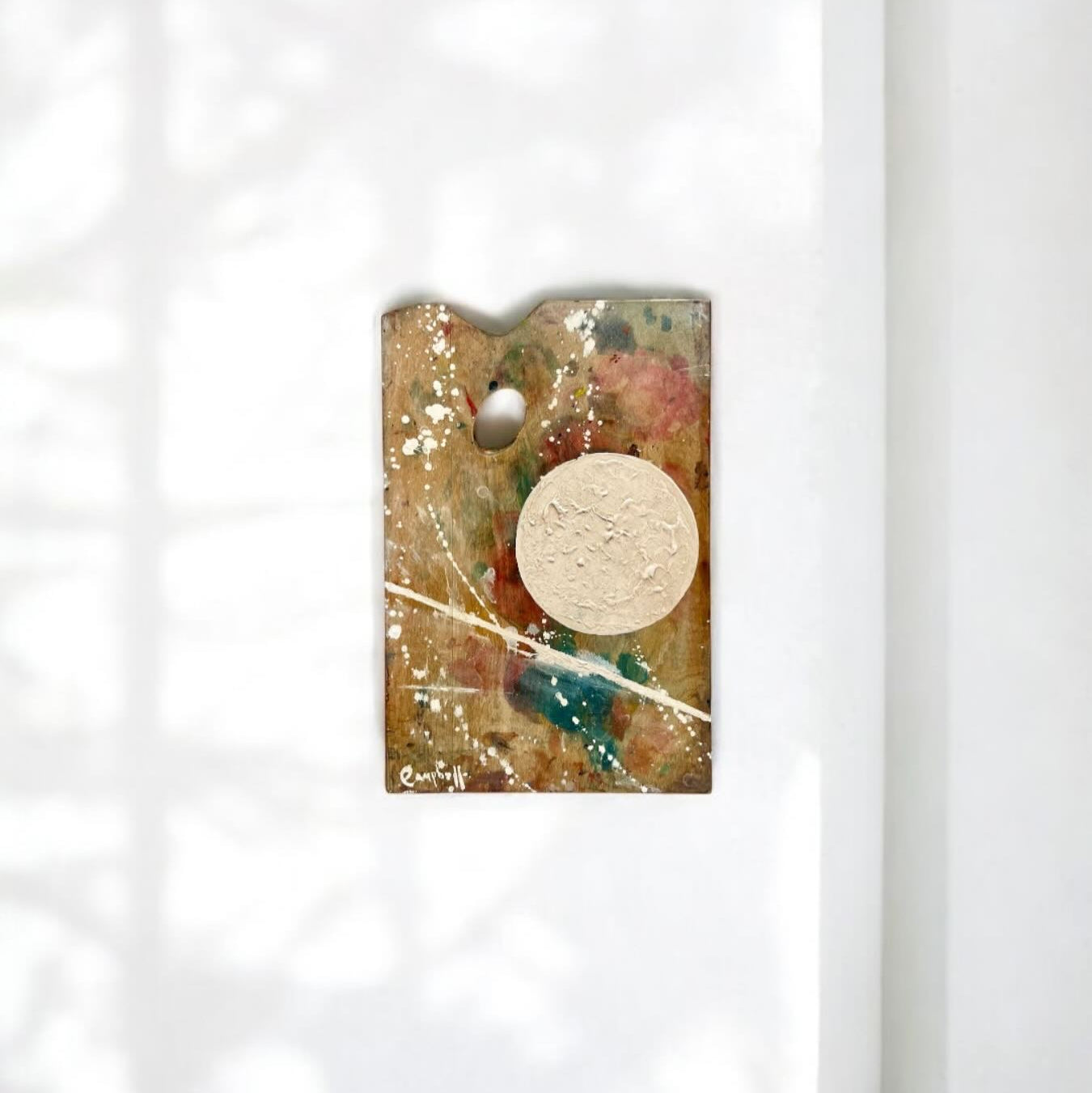 Decorative wall hanging with abstract design on a white background