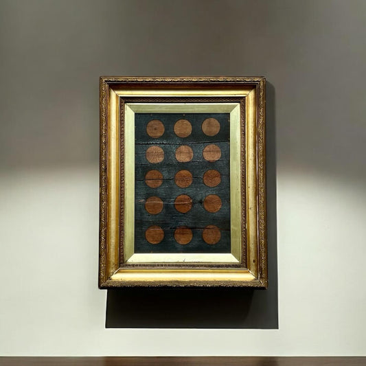 Framed artwork with circular patterns on a gray wall
