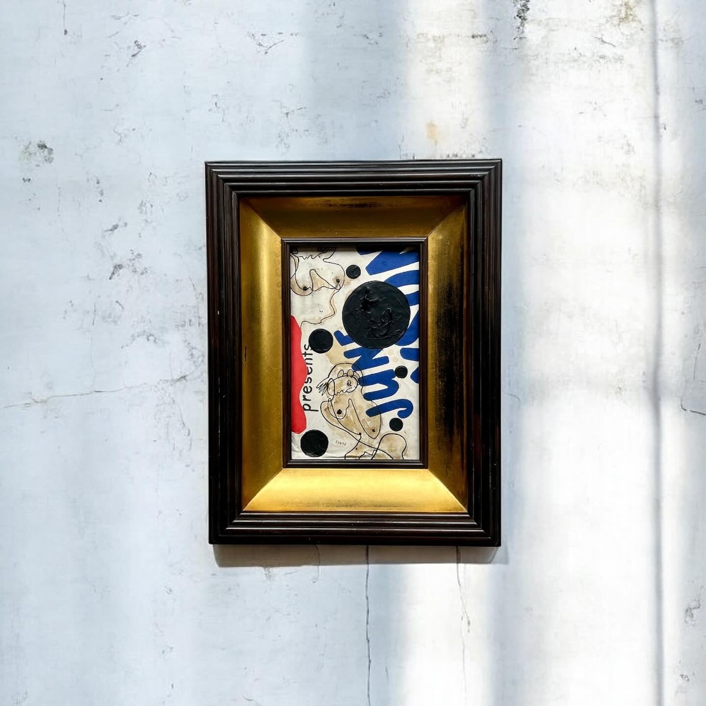 Framed artwork with abstract design on a textured wall
