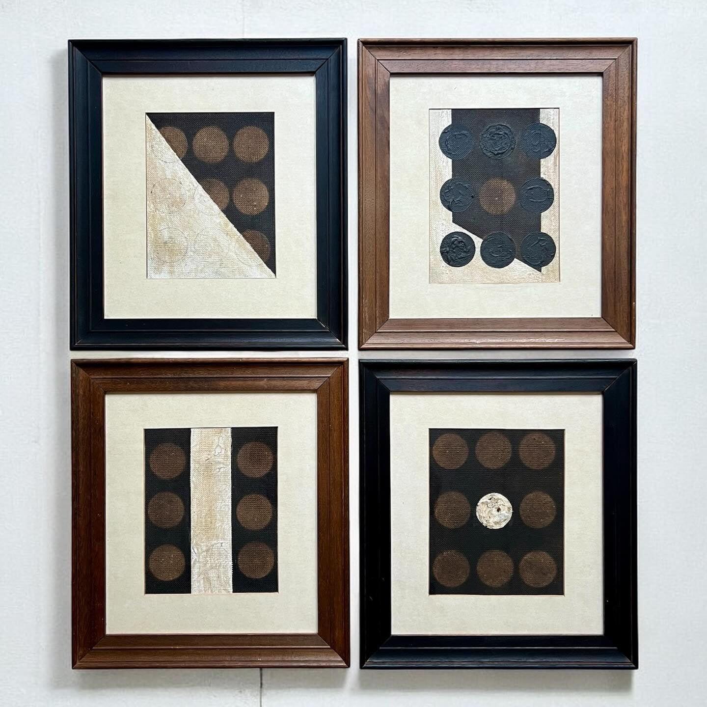 Four framed artworks with geometric patterns on a white wall.